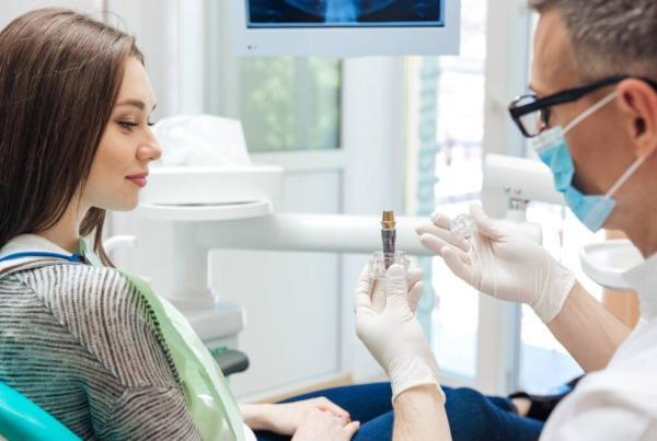 fogorvos a fogászati implantálás kérdéseire válaszol egy hölgy páciensnek