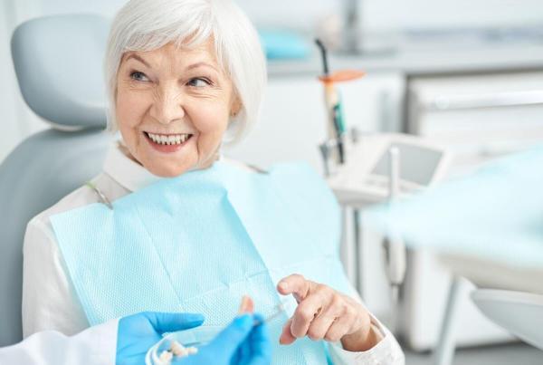 fog implantálás után idősebb hölgy kérdései kapcsán a fogorvosra néz