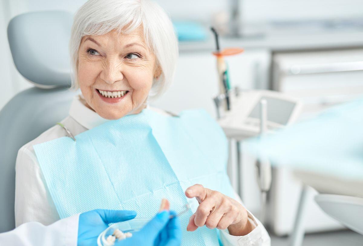 fog implantálás után idősebb hölgy kérdései kapcsán a fogorvosra néz